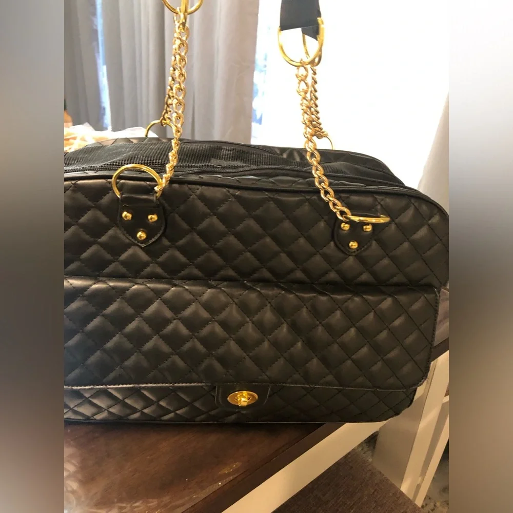 black quilted pet carrier tote with gold chain handles.